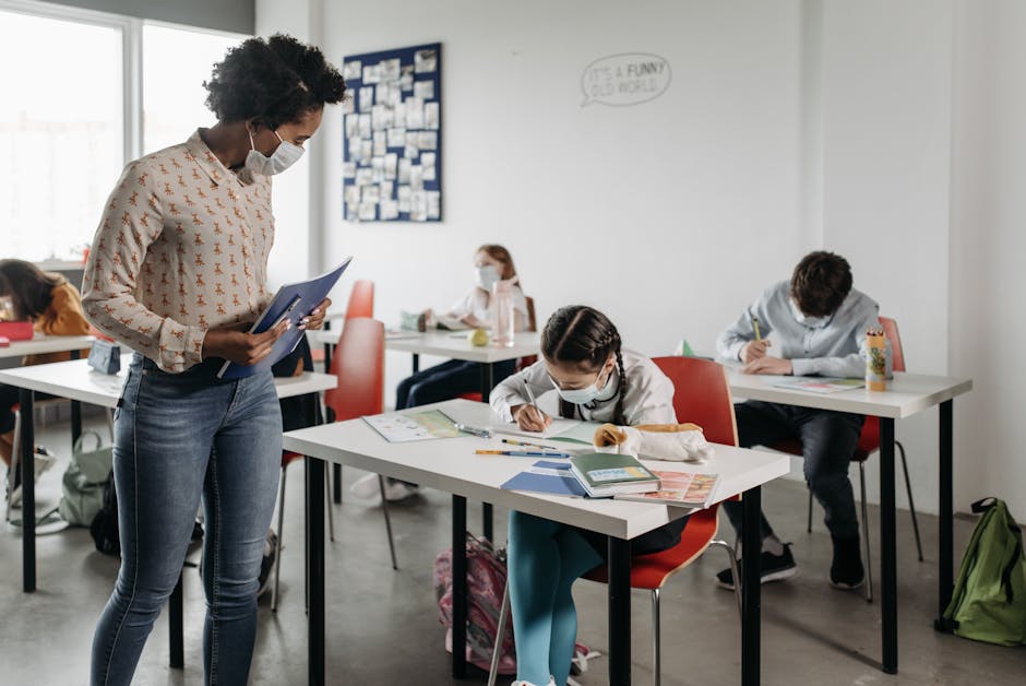 Students and teacher wearing masks in a diverse, modern classroom, focusing on education.
